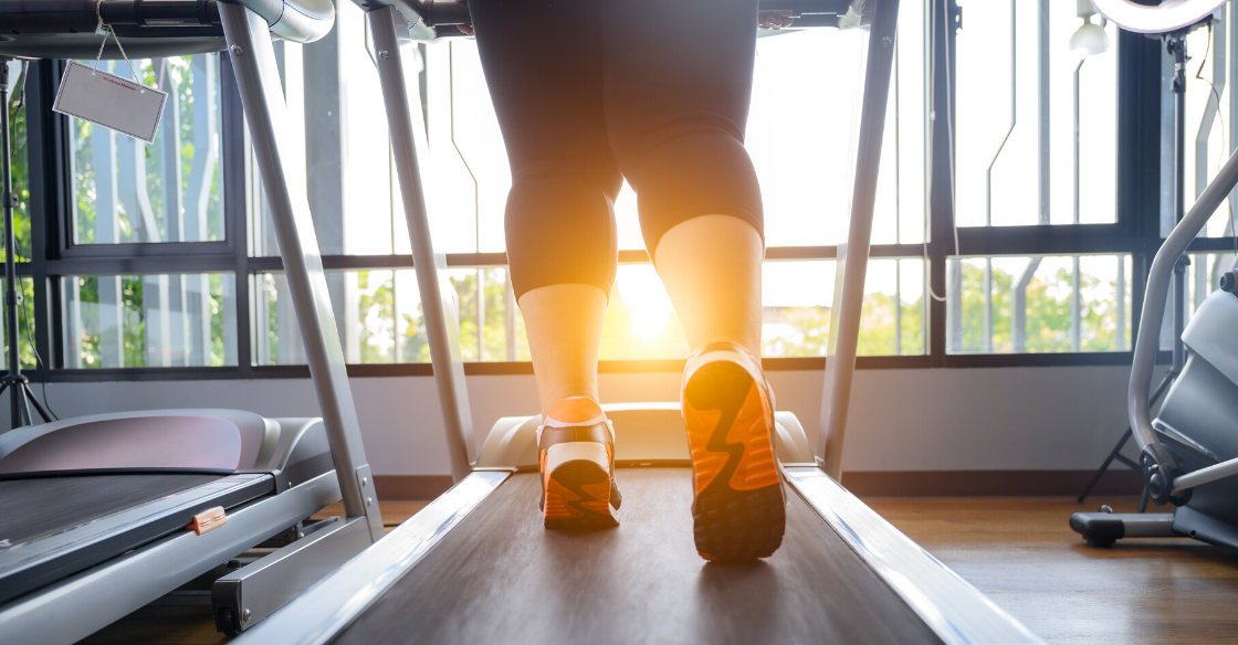 Overweight woman walking on treadmill