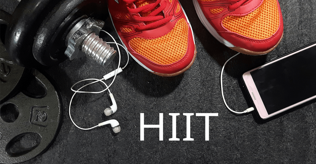 Running shoes, a weight, phone and earbuds on a gym floor with the letters HIIT to illustrate weight training after gastric sleeve